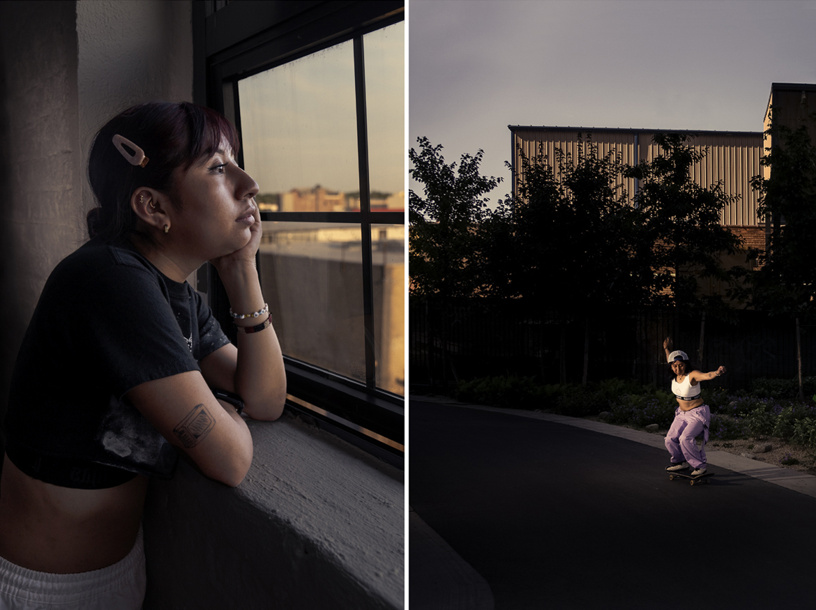 Portrait of a young Latina woman with purple dark hair and a pink hair clip and bangs, in a short-sleeved black crop-top and a tattoo on her upper arm, leans on a windowsill gazing out at golden hour, paired with the same woman in pink overalls pulled down to her waist, a white sports bra, white cap, skateboarding on a park path at dusk