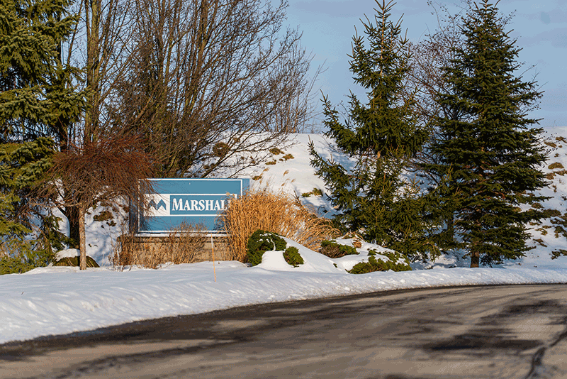 The Marshall BioResources sign surrounded by snow-covered trees in upstate New York.